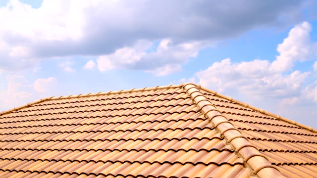 Time Lapse Of White Quick Clouds Passing Over A Roof Made Of Light Brown Tiles.
HD